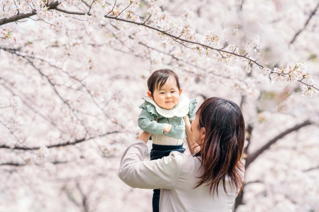 桜満開を背景にした赤ちゃん写真